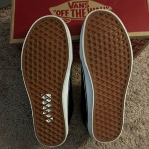 Vans, 8 & 1/2 black with white stripping around bottom and logo.